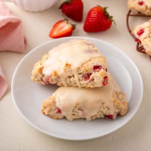 Two strawberry scones on a white plate.