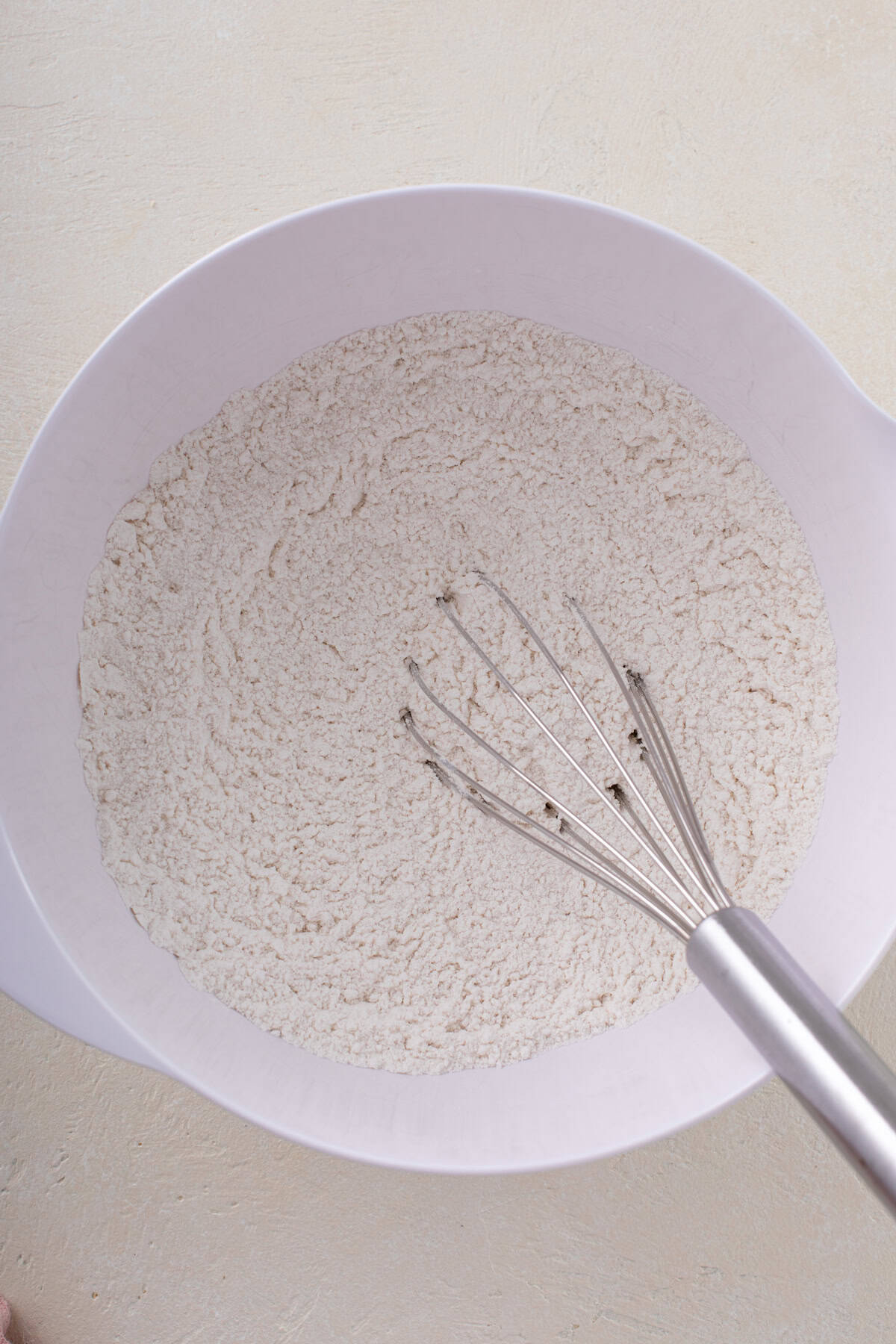 Dry ingredients for strawberry scone whisked in a white bowl.