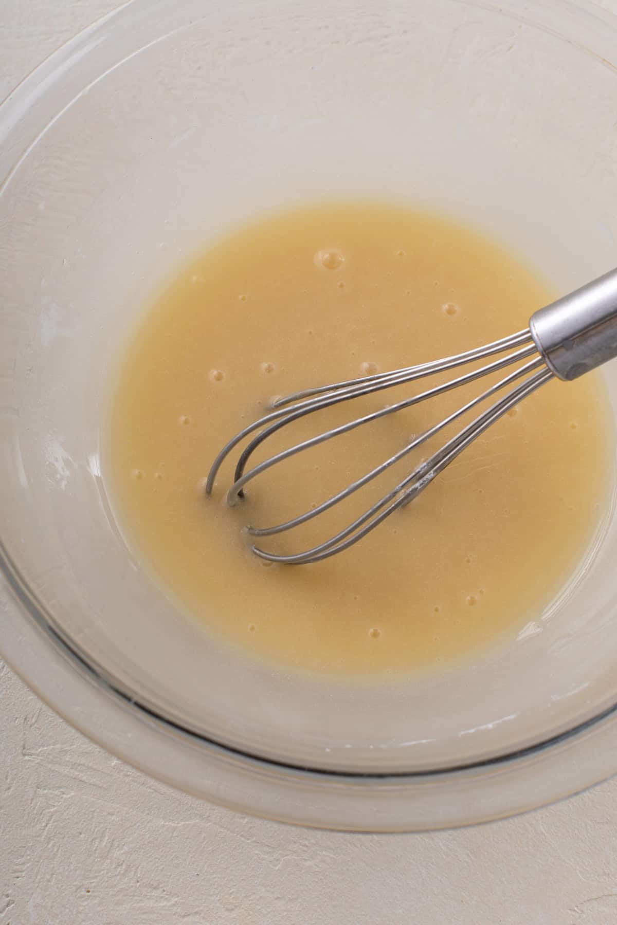 Vanilla glaze whisked in a glass bowl.