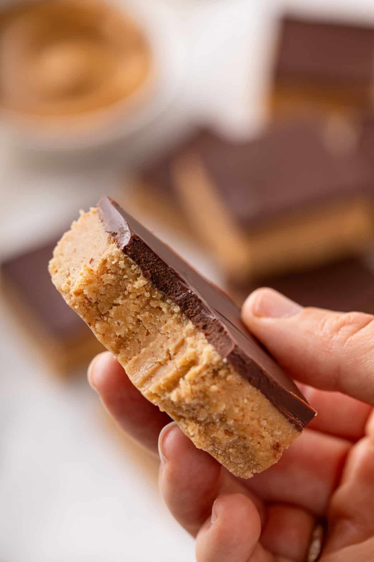 Person holding up a lunch lady peanut butter bar with a bite taken out of the corner.