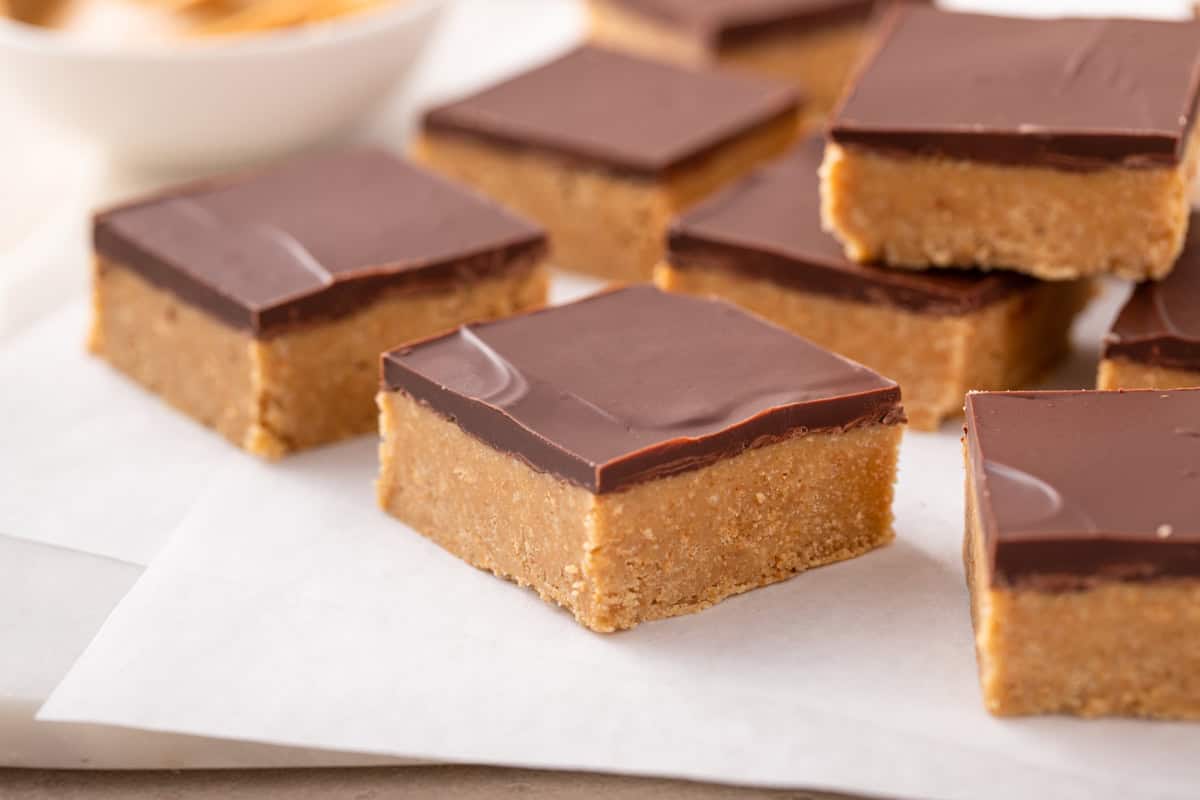 Side view of lunch lady peanut butter bars arranged on a piece of parchment paper.