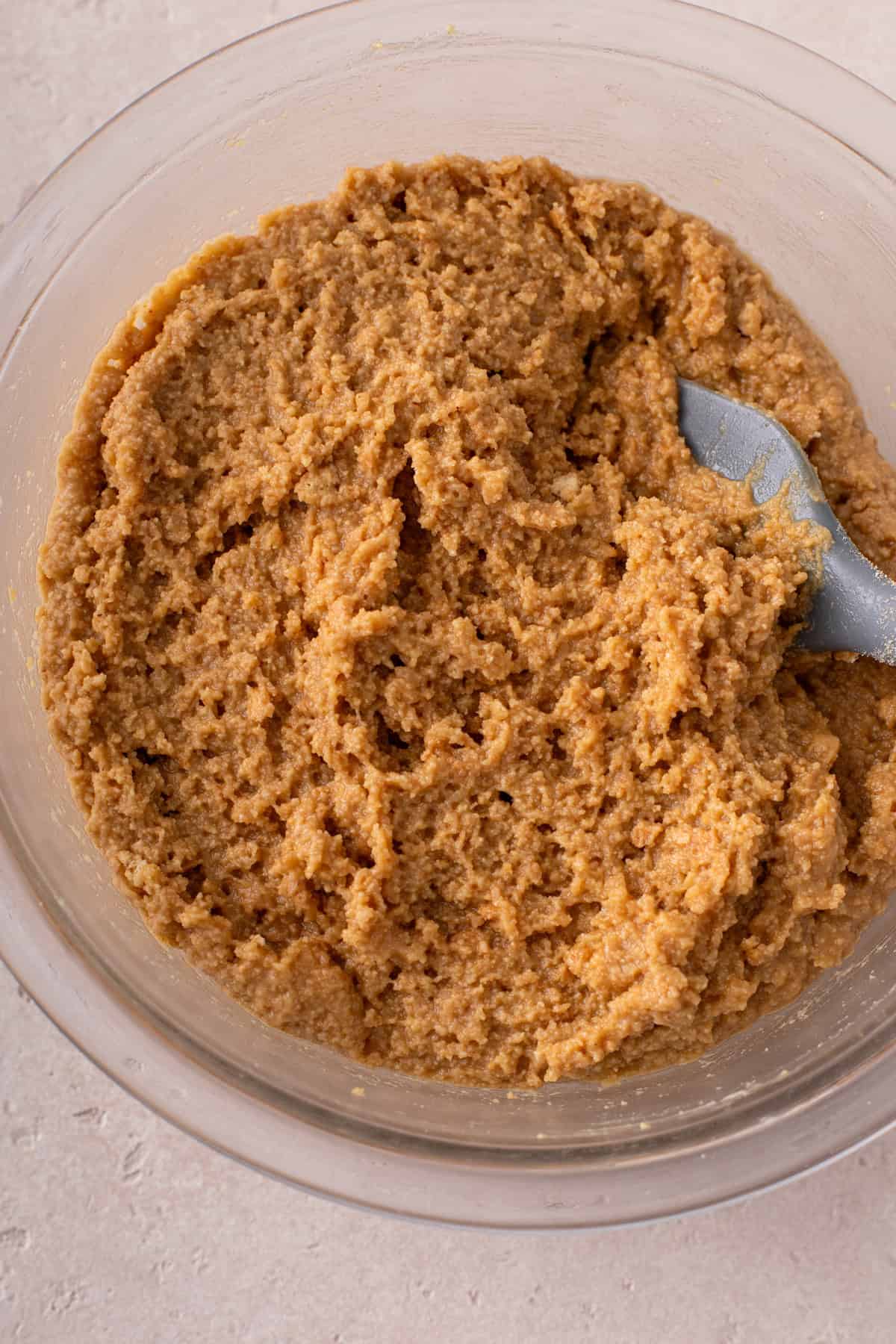 Peanut butter dough for the base of lunch lady bars mixed in a glass bowl.