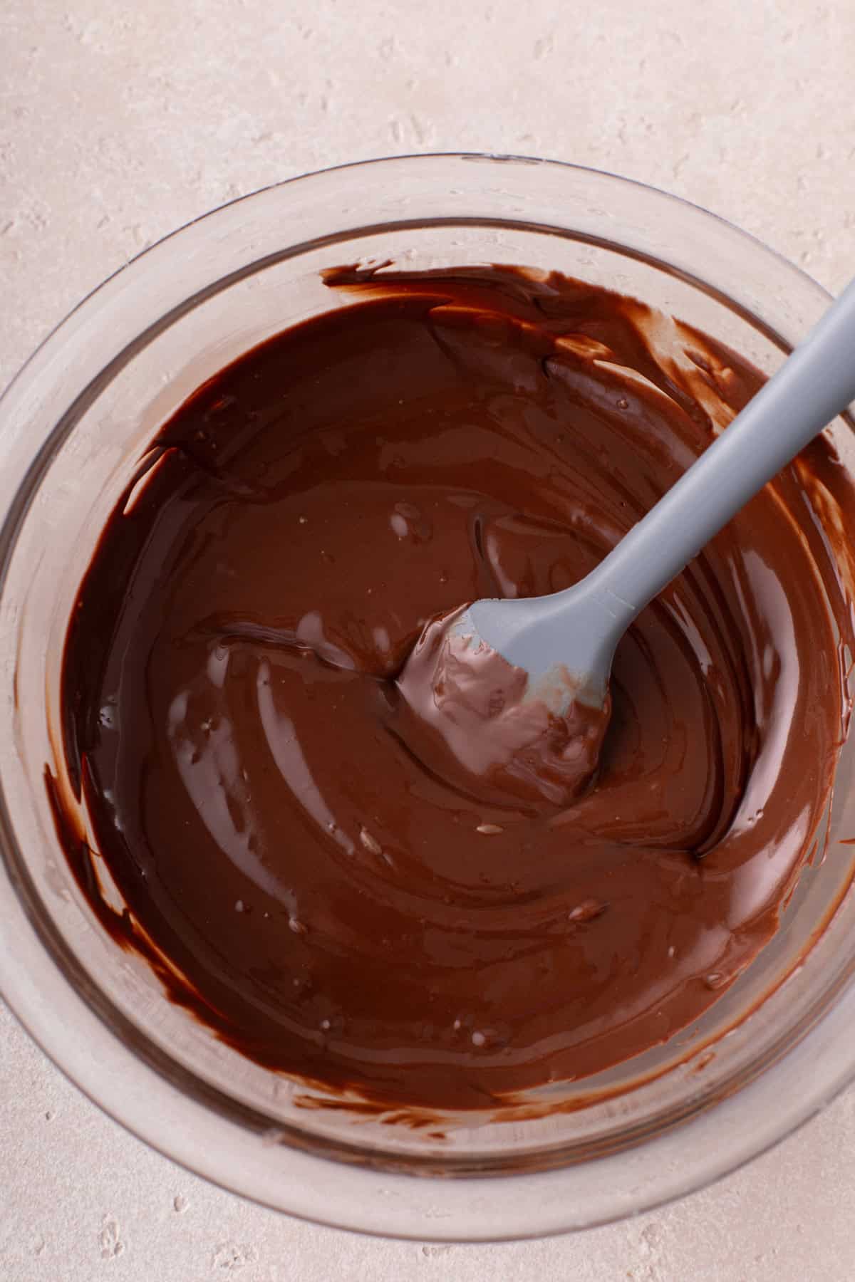 Chocolate and coconut oil melted together in a glass bowl.