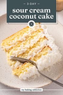 Fork cutting into a plated slice of sour cream coconut cake. Text overlay includes recipe name.