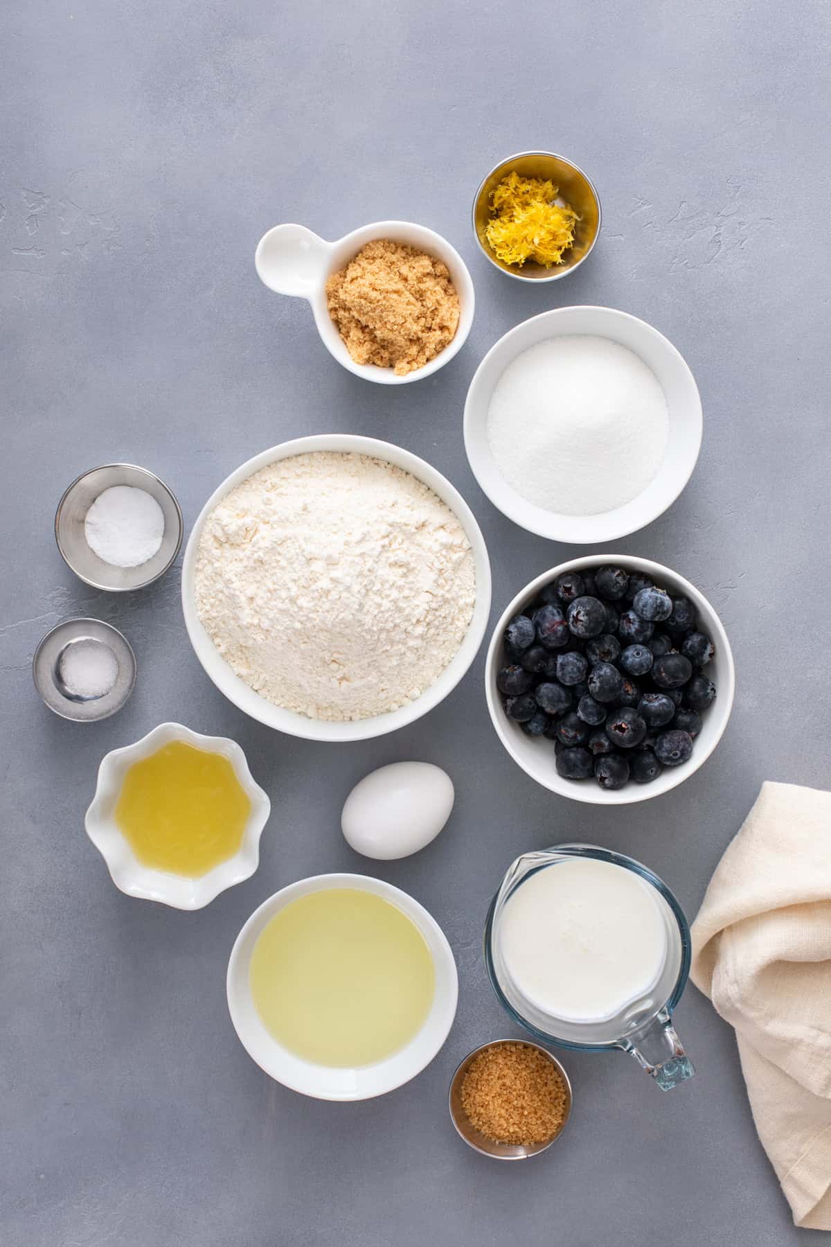 Ingredients for lemon blueberry muffins arranged on a countertop.