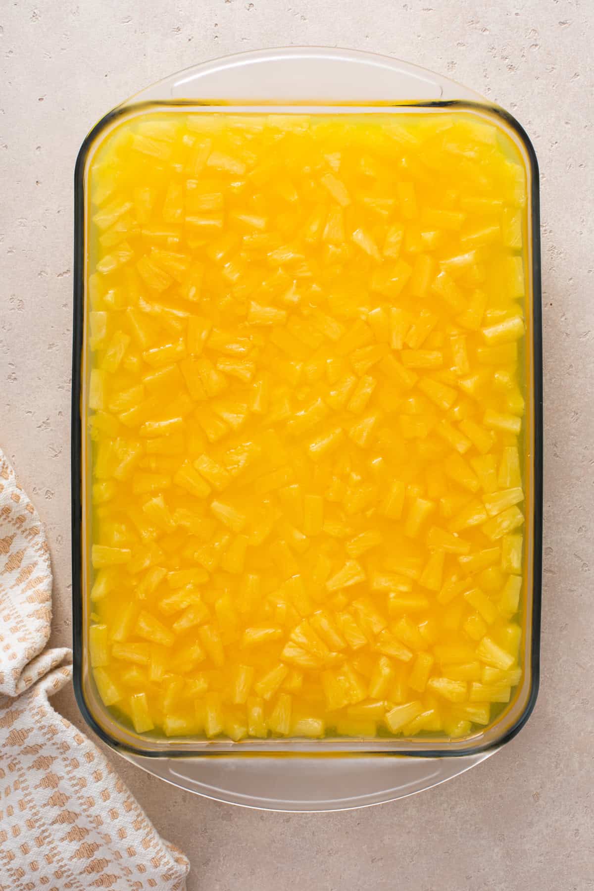 Pineapple topping spread over pineapple pretzel salad.