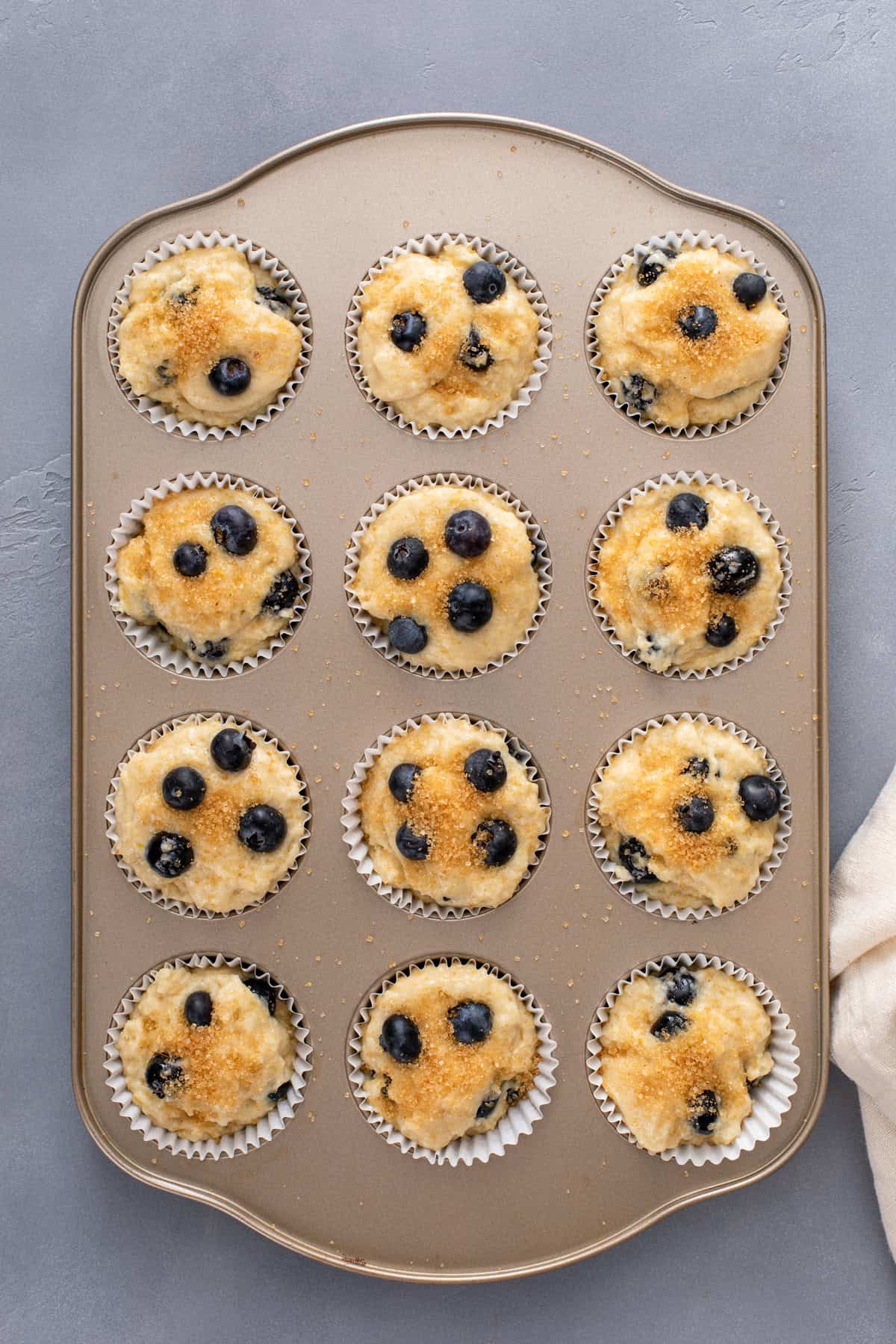 Unbaked lemon blueberry muffins in a muffin tin, ready to go in the oven.