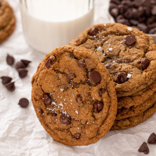 several espresso chocolate chip cookies next to a glass of milk.